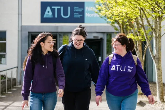 Three female students walking outside Dublin Road campus