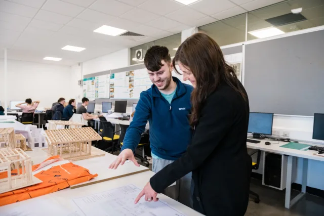 A student and lecturer are discussing some work in a design class