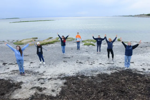 Group of students on beach with an ATU sign