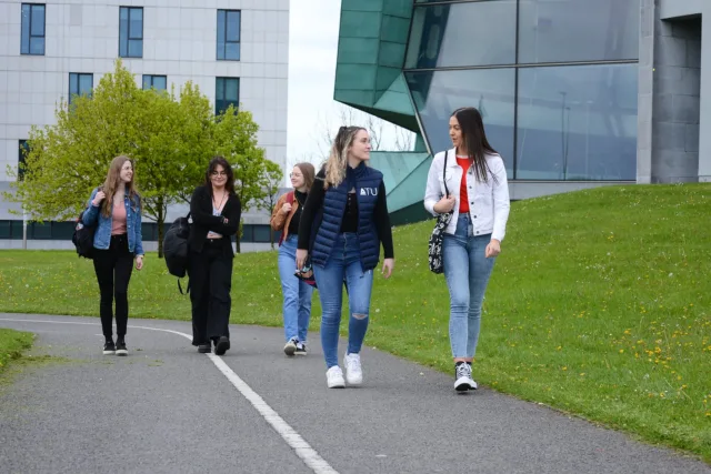 A group of students walking outside along a path