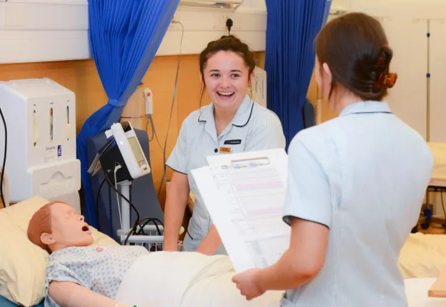 Nursing students are working together on a dummy patient