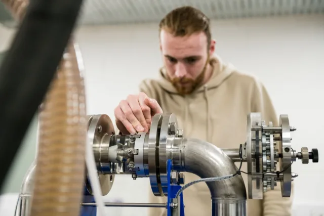 A student adjusting an engine