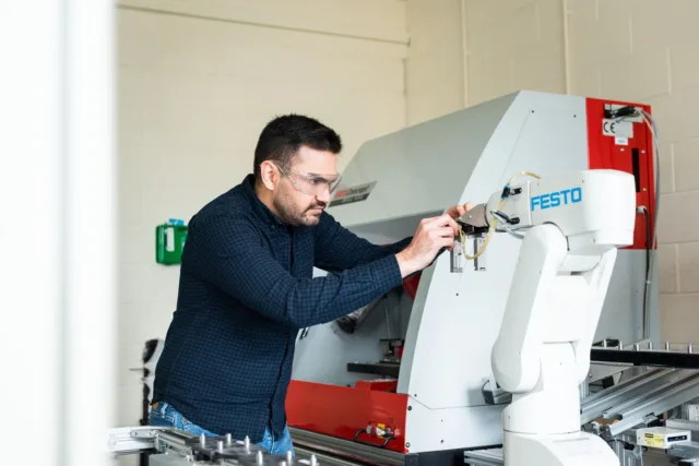 Student adjusting a robotic arm