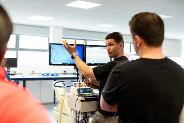 Student talking in front of computer screen