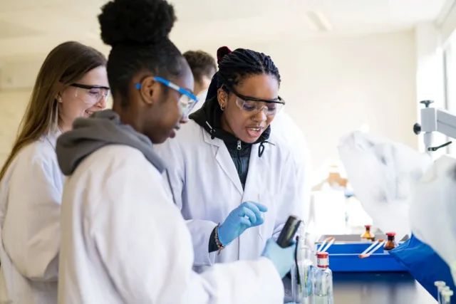 Student sitting at a desk with lab equipment