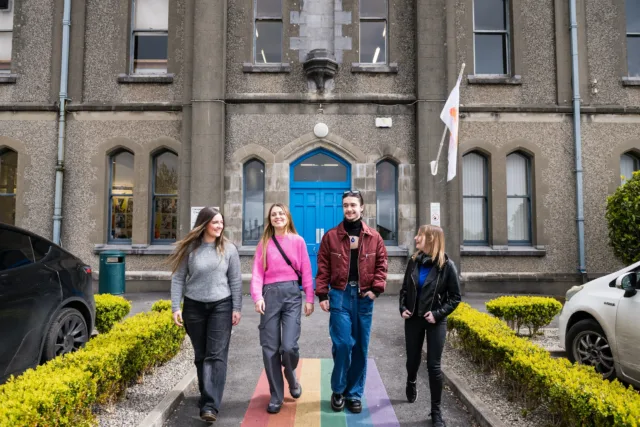 3 female students and 1 male student walking outside Wellpark campus