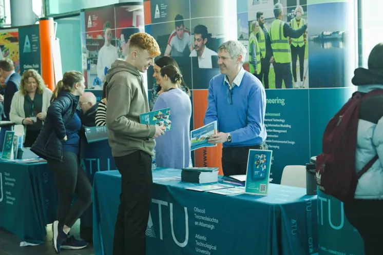 Undergraduate Student speaking to lecturer on campus during postgraduate information day