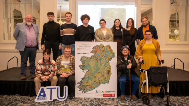 At the launch of the ATU Heritage student project with Irish Rail, pictured at the Hardiman Hotel in Galway City. Some group members stand on a small stage, while others sit. In the center of the stage, a map of Ireland is displayed alongside an ATU sign.