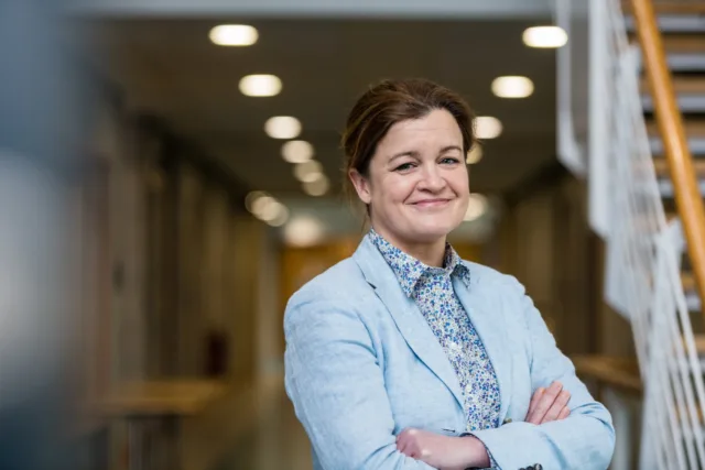 Mature, female student, arms crossed in the corridor of ATU Donegal Letterkenny campus