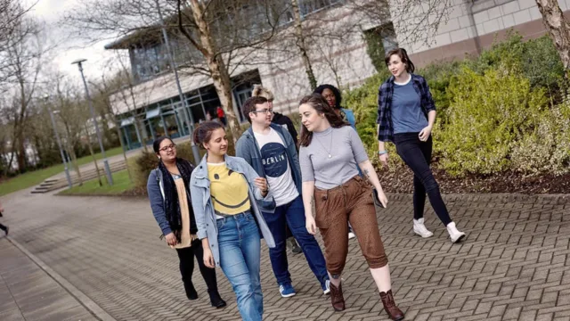 A group of students walking together on campus, chatting and heading in the same direction.