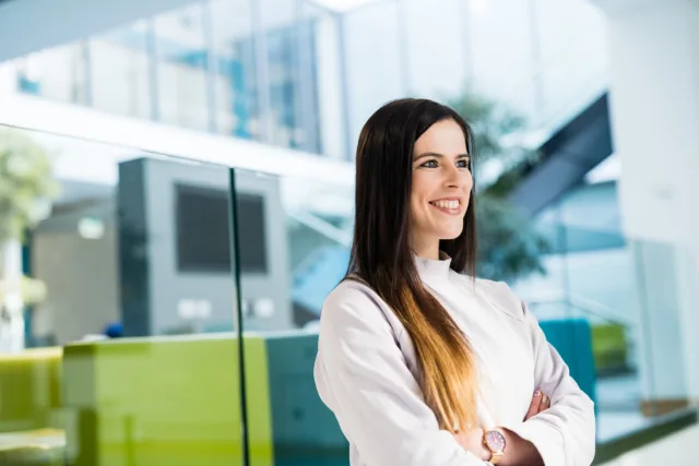 Female student looks out window with arms crossed