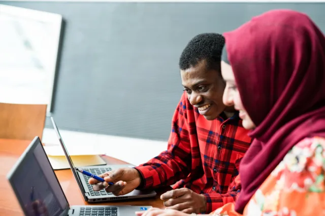 Two students looking at laptop together