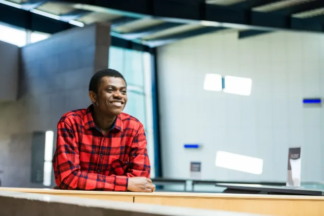 Student in red checkered shirt smiling in the ATU Galway City Library