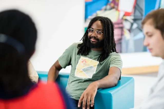 International student sitting in chair while engaging in social conversation