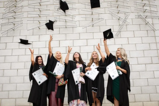 Graduates throwing cap in the air