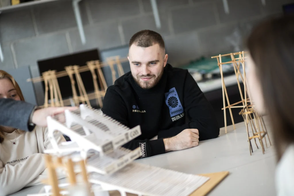 Male architecture student examining model house