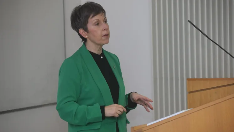 ATU President Dr. Orla Flynn, wearing a green suit jacket, stands behind a lectern addressing the crowd.