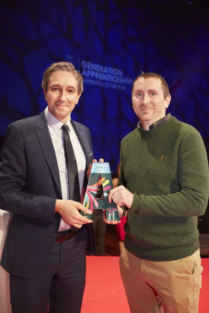 The winner receives his trophy from Minister Simon Harris during the awards ceremony.