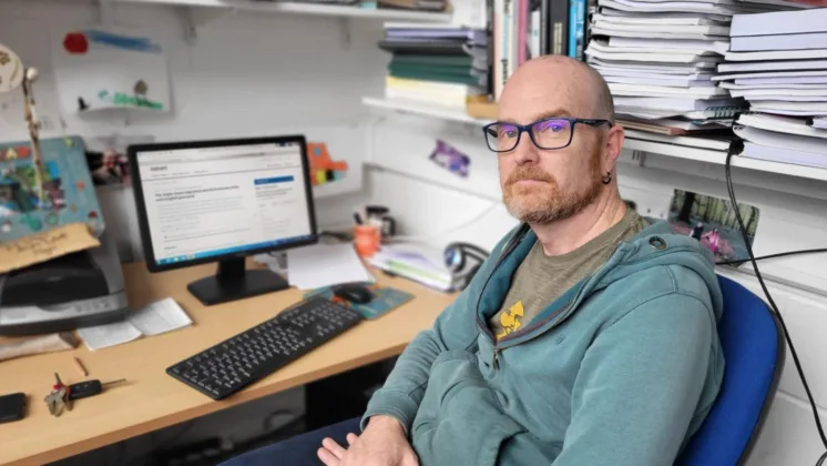 Chris Read, lecturer at ATU, working at his office desk with materials and a computer in front of him.