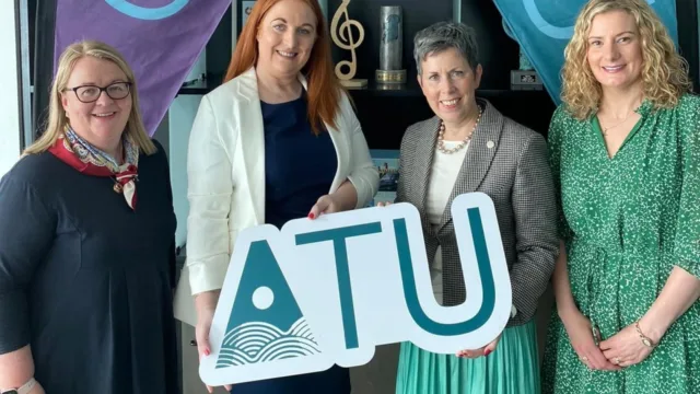 Cáit Noone, Head of the Galway International Hotel School at ATU; Áine Doyle, Head of the Learning Academy at Dalata Hotels; Dr. Orla Flynn, President of ATU; and Martha Manion, Director of Revenue Management at Dalata Hotels, hold an ATU sign together.