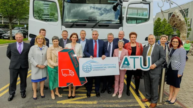 A group of stakeholders posing for a photo in front of a lorry.