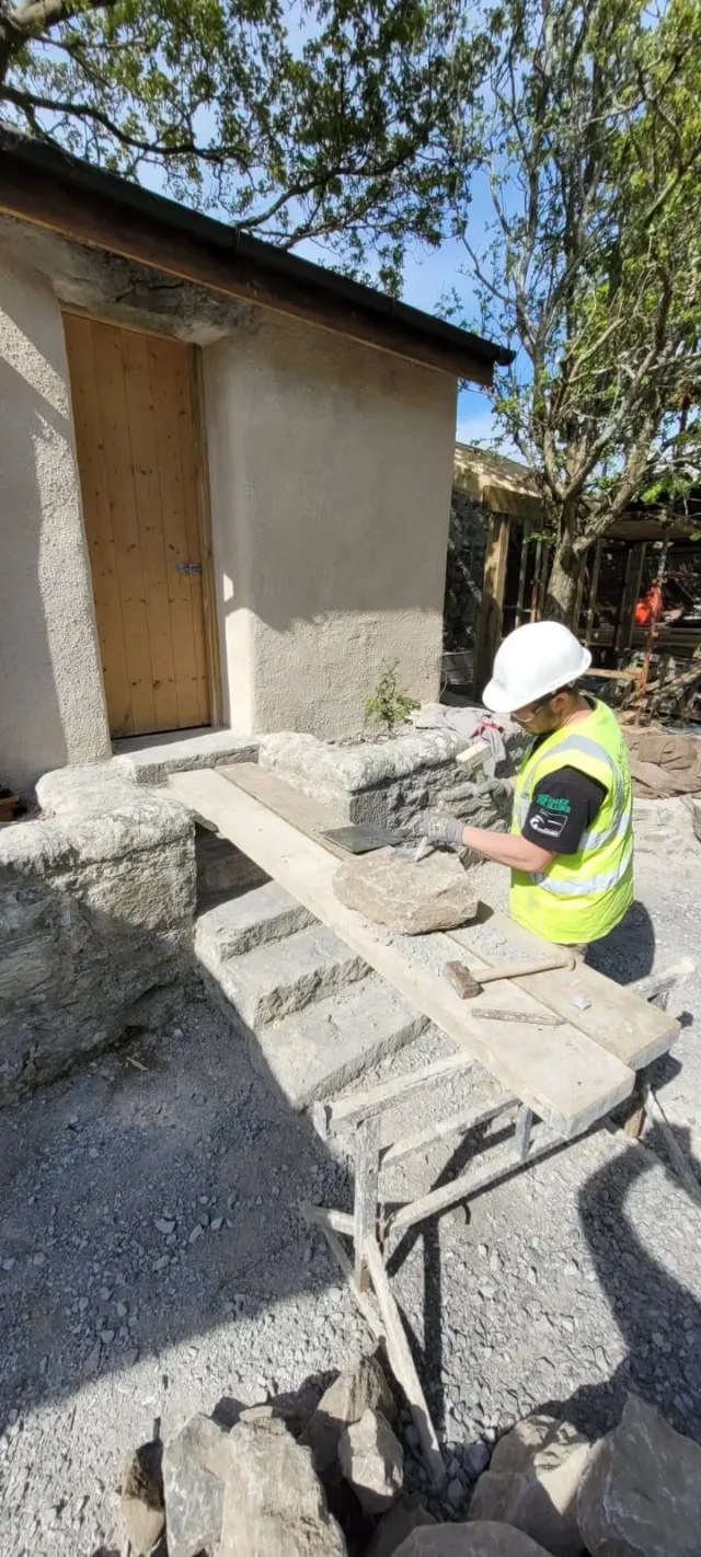 An employee demonstrating shaping stone and lime plaster.