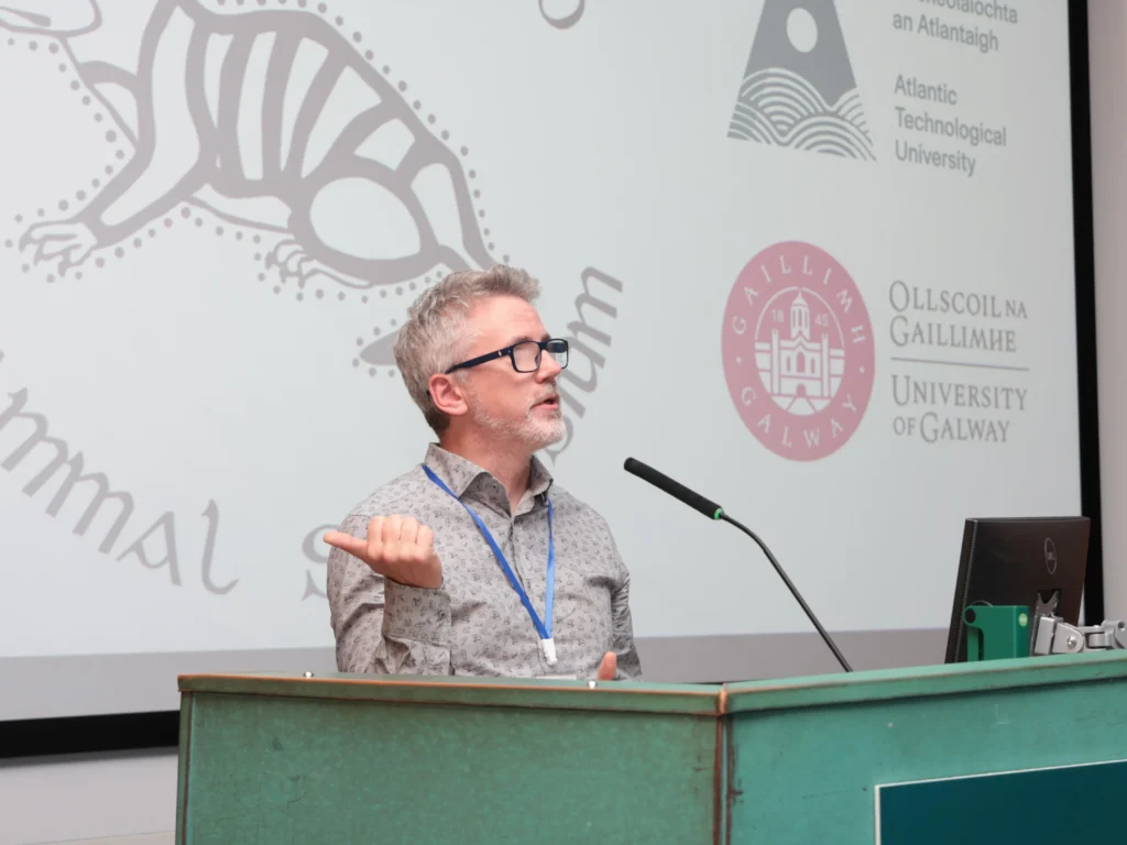 man speaking on podium at All Ireland Mammal symposium