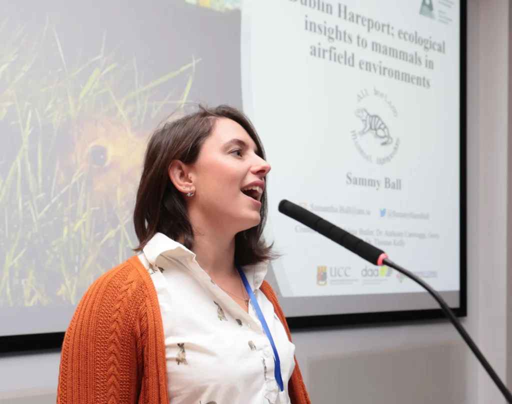 woman speaking on podium at All Ireland Mammal symposium