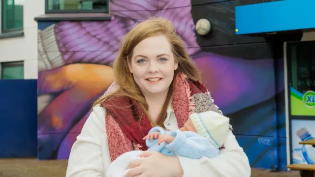 woman with red hair holding newborn baby