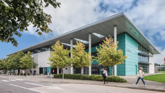 A photo of the sports hall on the ATU Letterkenny campus, showing the front entrance, path, and surrounding road.