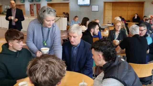 Lecturer and students sit around table