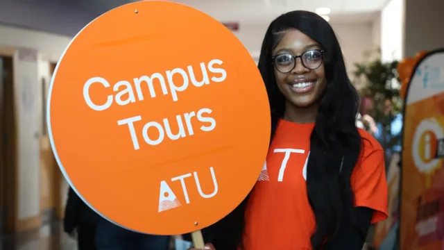 student holding campus tours sign