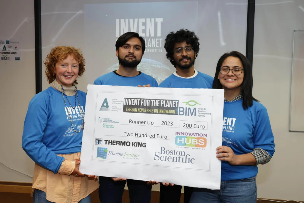 students in blue tshirts holding prize cheque