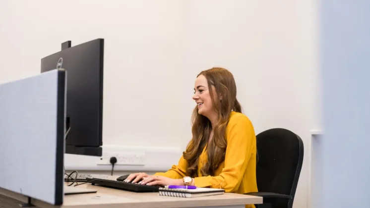 Woman types on keyboard at a desk