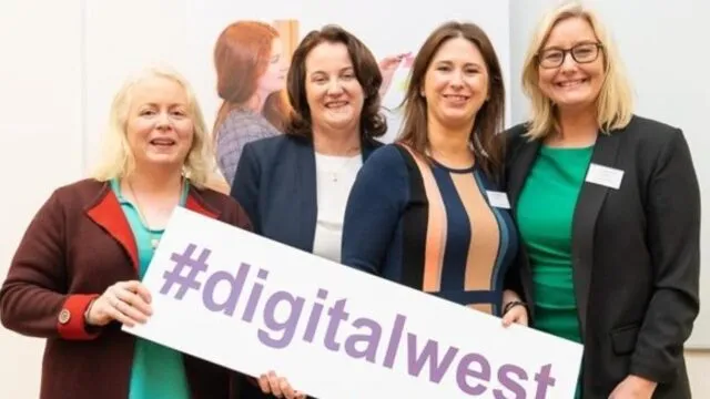 4 women stand with digital west sign