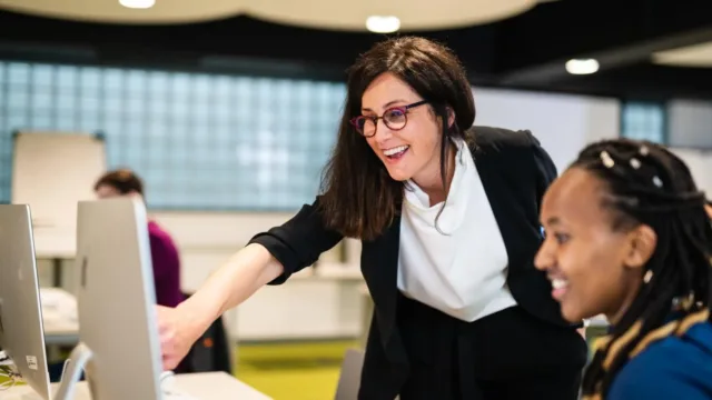 women pointing to computer screen