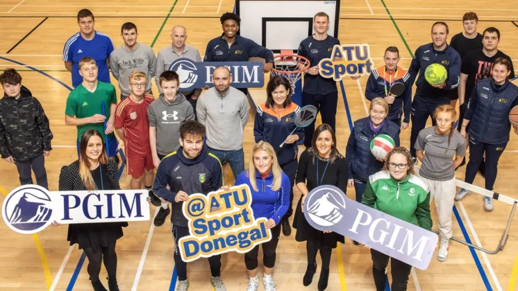 In the sports hall, PGIM representatives Aisling McDevitt and Julija Ciubarova, along with members and staff from Donegal Youth Service, Basketball Ireland North West Development Officer Laura Deeney, ATU International Basketball Scholars Christian Simmons and Ryan Ganniclefft, Paul Nelis (Teacher at St. Eunans College), Rory McMorrow (Student Services Manager), Michael Murphy (Head of Sport ATU Donegal), Helen Kennedy (Sports Centre Manager ATU Donegal), ATU Donegal Sport Centre Staff, and ATU Donegal students Eoin McKenna and Katie Gibbons, are pictured holding sporting equipment such as basketballs, footballs, tennis racket and more.