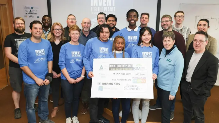 students in blue tshirts holding prize cheque