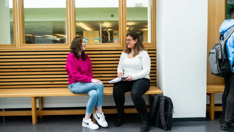 Project wave students sit chatting on a bench