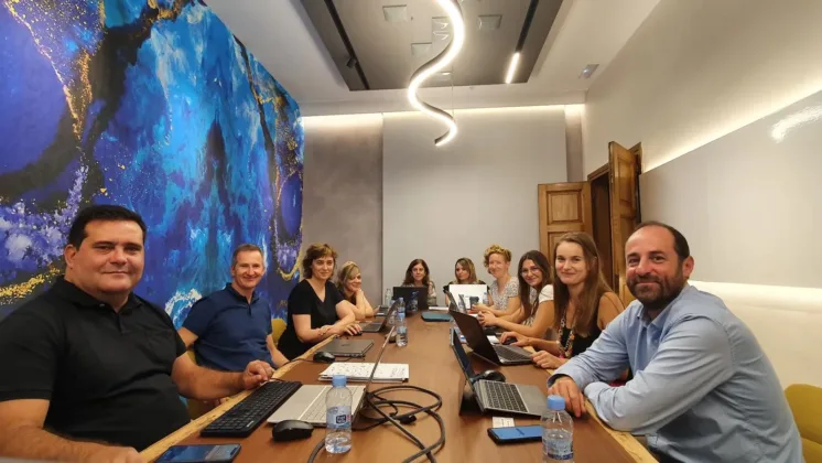 men and women sit around a table in board room