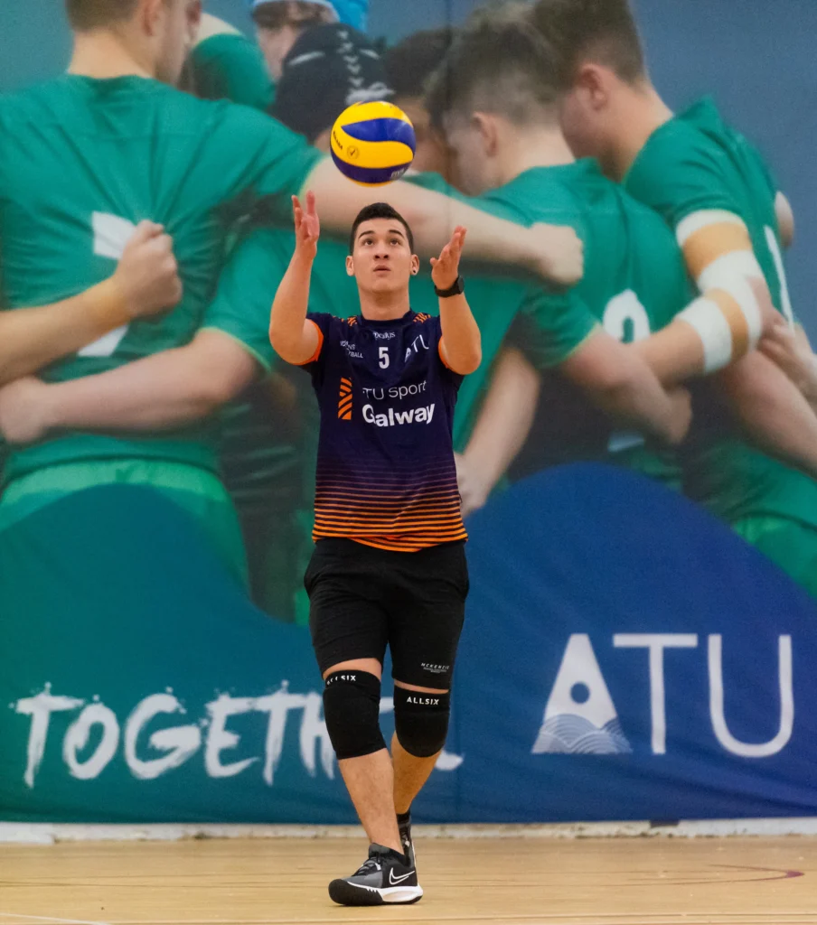 Male student in sports gear throws ball into the air