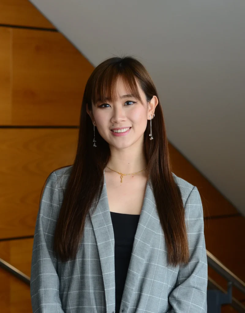 Female international student faces camera wearing grey blazer