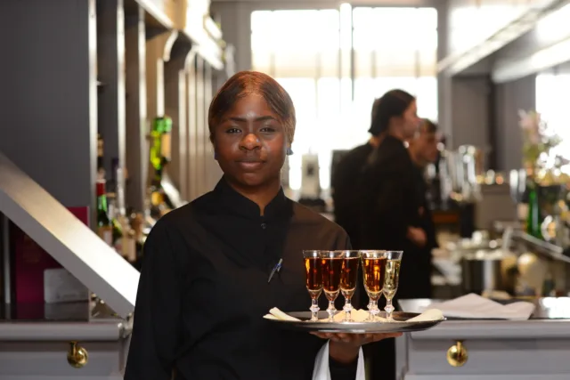 Female student holds tray of drinks in the Galway International Hotel School