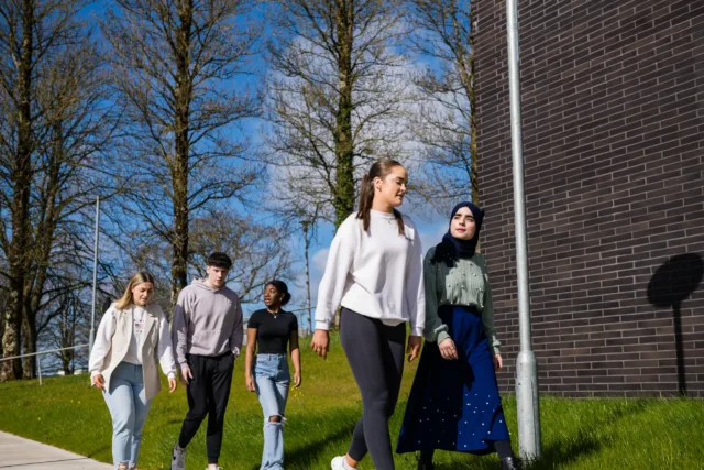 a group of students walking a pathway outdoors