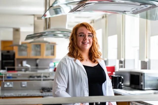 Home economics student stands in teaching kitchen in St Angelas.