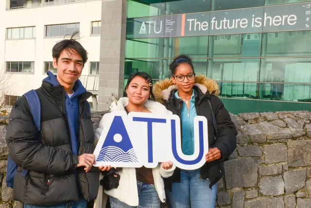 Three students holding ATU sign at an ATU Open Day event