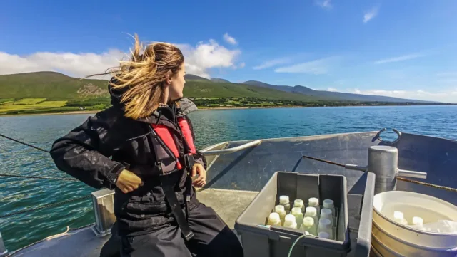 Researcher on boat wearing life jacket