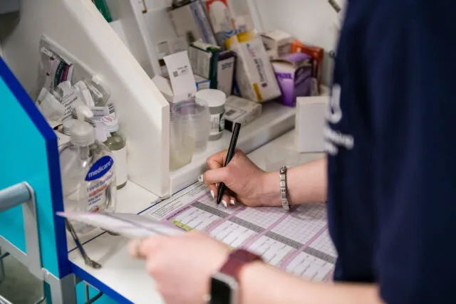 Student writes into medicine log