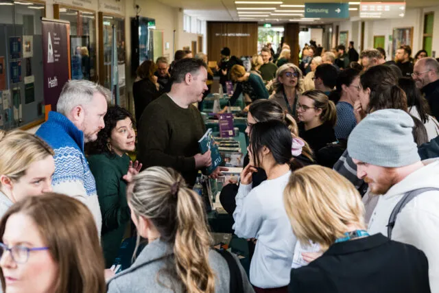 Crowd of students interacting with programme teams at stands at ATU Postgraduate Information Day in Sligo, 2025